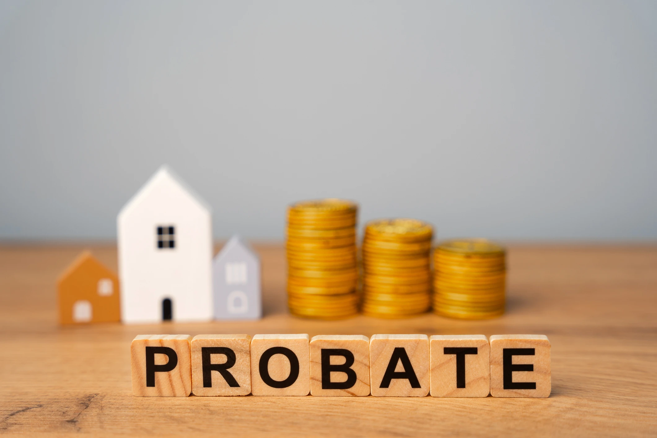 Probate concept with houses and coin stacks.